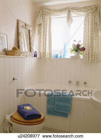 Stock Photo - Pink bathroom with white tongue+groove panelling and pink floral curtains. Fotosearch