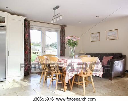 Pink checked cloth on table with pine chairs in modern dining room extension View Large Photo Image Stock Photograph - Pink checked cloth on table with pine chairs in modern dining room extension. Fotosearch