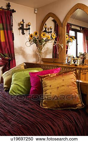 Pink Gold And Green Silk Cushions On Bed With Dark Red