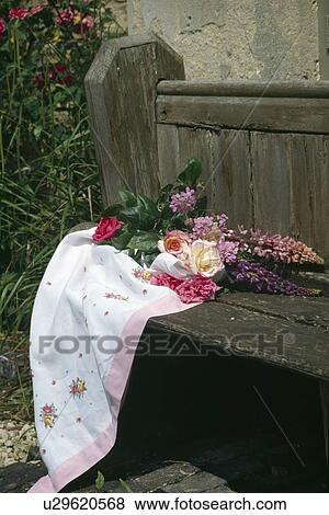 Stock Photo - Pink roses and lupins with pink+white cloth on old wooden bench. Fotosearch