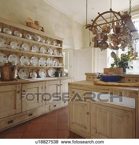 Plates On Antique Pine Dresser In Country Kitchen With Saucepans