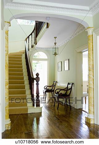 Stock Photograph - Polished wooden floorboards in Georgian hall with cream stair carpet. Fotosearch