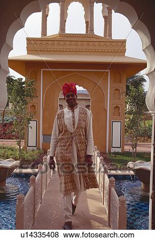 Portrait of man in traditional Rajastani clothes crossing bridge over stream in Rajvilas Hotel View Large Photo Image Stock Photo - Portrait of man in traditional Rajastani clothes crossing bridge over stream in Rajvilas Hotel. Fotosearch