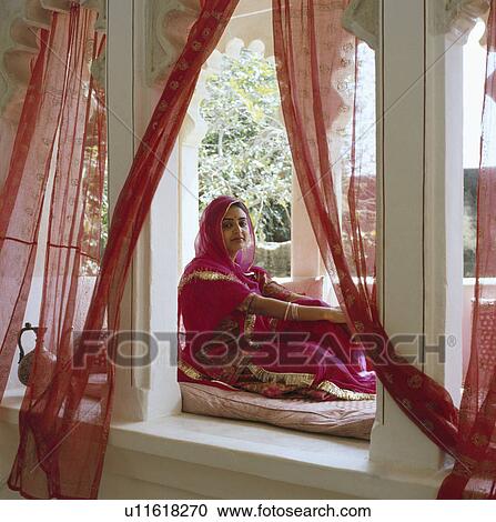 Portrait of woman in red sari sitting in Rajastan pavilion with red voile drapes View Large Photo Image Stock Image - Portrait of woman in red sari sitting in Rajastan pavilion with red voile drapes. Fotosearch