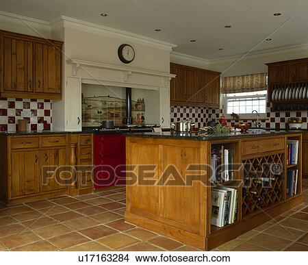 Picture - Quarry floor tiles in country kitchen with fitted oak cupbaords and large island unit. Fotosearch