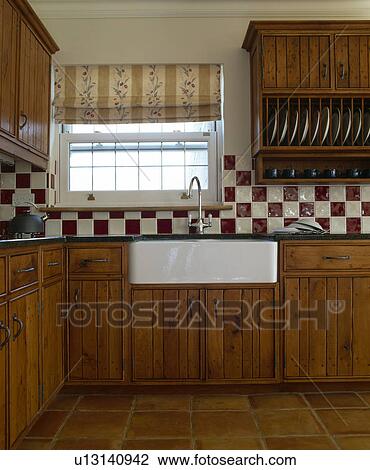 Red and white wall tiles in country kitchen with fitted oak units View Large Photo Image Stock Image - Red and white wall tiles in country kitchen with fitted oak units. Fotosearch