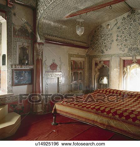 Red and yellow Indian bedcover on bed in Rajastani bedroom with floral mosaic tiled walls and ceiling View Large Photo Image Stock Photograph - Red and yellow Indian bedcover on bed in Rajastani bedroom with floral mosaic tiled walls and ceiling. Fotosearch