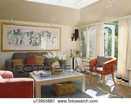 Stock Image - Red armchairs and grey sofa in living room extension. Fotosearch
