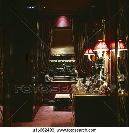 Red wall-lights above chest of drawers in dark dressing-room View Large Photo Image Stock Image - Red wall-lights above chest of drawers in dark dressing-room. Fotosearch