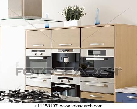 Row of ovens in fitted unit in modern kitchen View Large Photo Image Stock Photo - Row of ovens in fitted unit in modern kitchen. Fotosearch