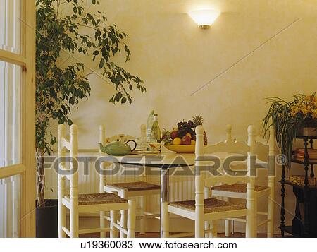 Rush-seated chairs and circular table in economy-style cream dining room View Large Photo Image Stock Image - Rush-seated chairs and circular table in economy-style cream dining room. Fotosearch