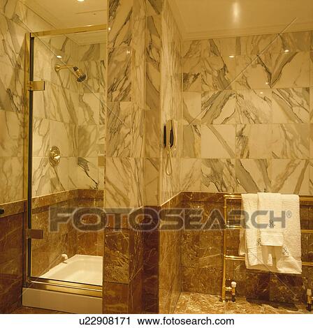 Stock Image - Shower cabinet with glass door in marble bathroom. Fotosearch