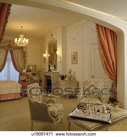 Silver teaset on table in front of 18th century-style armchairs in large townhouse bedroom View Large Photo Image Stock Image - Silver teaset on table in front of 18th century-style armchairs in large townhouse bedroom . Fotosearch