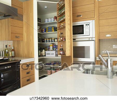 Sink In White Corian Worktop In Small Kitchen With Open Larder