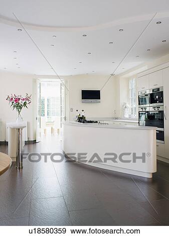 Stock Photo - Slate flooring in large modern white kitchen. Fotosearch