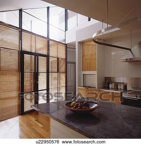 Slatted blinds on glass doors in modern kitchen with black granite worktops View Large Photo Image Stock Photograph - Slatted blinds on glass doors in modern kitchen with black granite worktops. Fotosearch