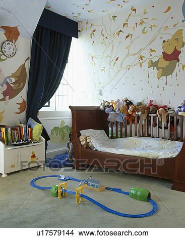 Sleigh bed and hand-painted mural on walls of child's bedroom with train track on floor View Large Photo Image Picture - Sleigh bed and hand-painted mural on walls of child's bedroom with train track on floor. Fotosearch