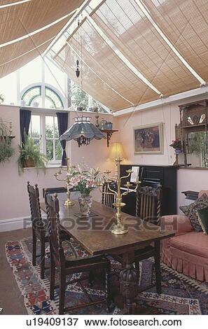 Split cane blinds in conservatory extension dining room with pendant light above oak table and chairs View Large Photo Image Stock Photo - Split cane blinds in conservatory extension dining room with pendant light above oak table and chairs. Fotosearch