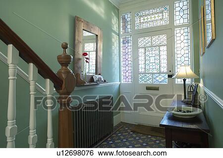Stock Photograph - Stained glass windows and half-glazed door in traditional green hall. Fotosearch
