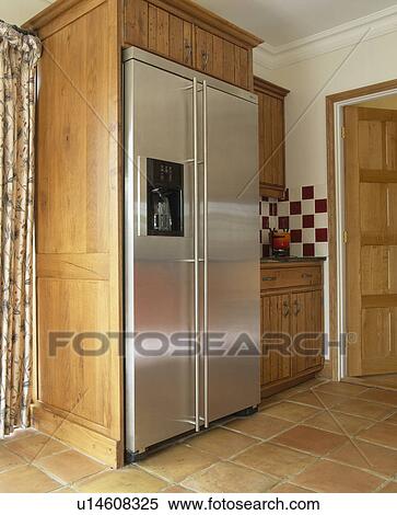 Stock Photography - Stainless steel American-style fridge freezer in traditional kitchen. Fotosearch