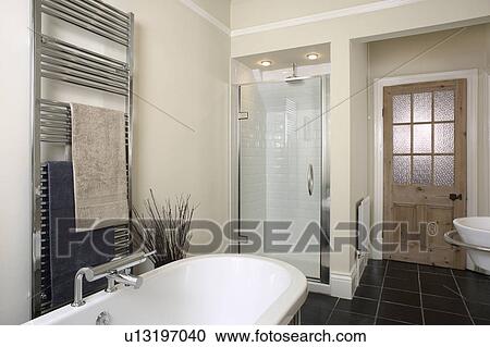 Stainless steel heated towel rail above bath in beige bathroom View Large Photo Image Stock Image - Stainless steel heated towel rail above bath in beige bathroom. Fotosearch