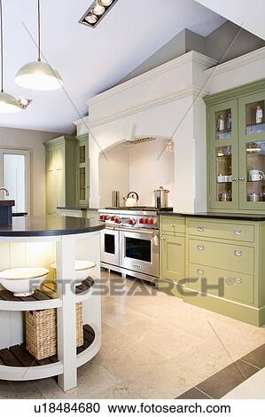 Stock Image - Stainless steel range oven in modern white kitchen with green fitted dresser. Fotosearch