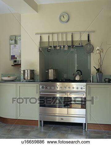 Stock Photograph - Stainless steel range oven in modern cream kitchen with pale grey units. Fotosearch