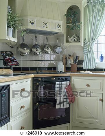 Stainless steel saucepans on rack above corner oven in traditional country kitchen View Large Photo Image Stock Photo - Stainless steel saucepans on rack above corner oven in traditional country kitchen. Fotosearch