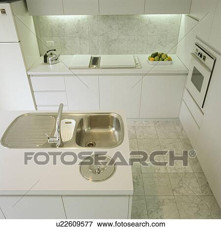 Stainless steel sink and marble tiled floor in modern white kitchen View Large Photo Image Stock Photo - Stainless steel sink and marble tiled floor in modern white kitchen. Fotosearch