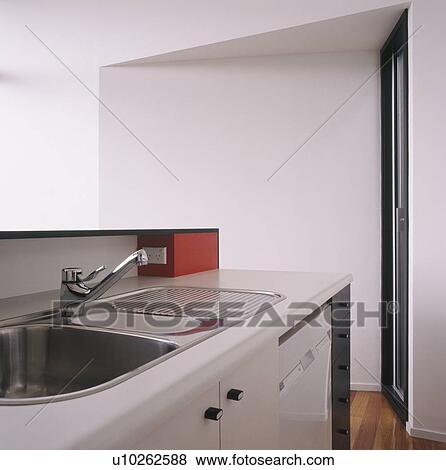 Stock Photo - Stainless steel sink in modern white kitchen unit. Fotosearch
