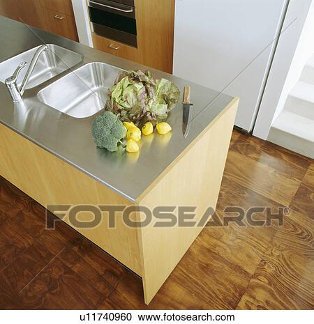 Stock Image - Stainless steel splashback double sink and worktop in modern kitchen. Fotosearch
