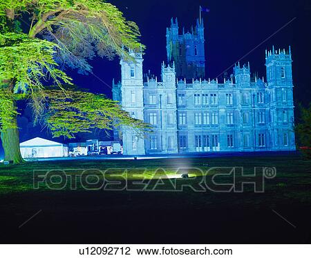 Stock Image - Stately home lit at night with marquee on the lawn. Fotosearch