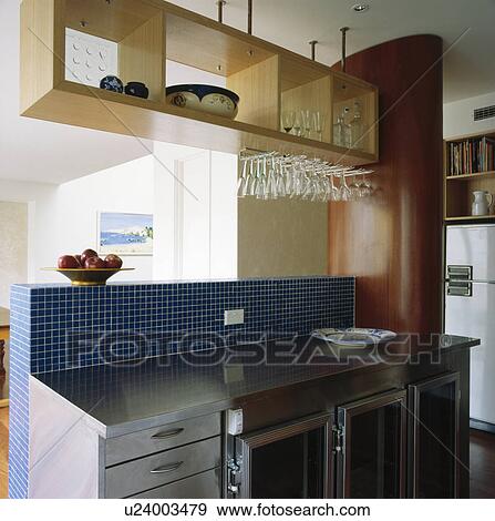 Storage shelf above stainless steel fitted units with blue mosaic tiled splashback View Large Photo Image Stock Photo - Storage shelf above stainless steel fitted units with blue mosaic tiled splashback. Fotosearch