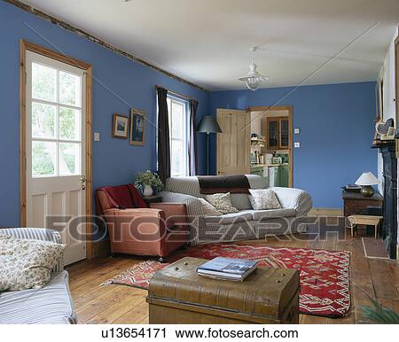 Striped sofas and old chest in blue country living room with oriental rug on wooden flooring View Large Photo Image Stock Image - Striped sofas and old chest in blue country living room with oriental rug on wooden flooring. Fotosearch