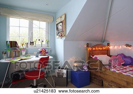 Teenager's pastel blue attic bedroom with novelty fairy lights above wooden bed View Large Photo Image Stock Image - Teenager's pastel blue attic bedroom with novelty fairy lights above wooden bed. Fotosearch