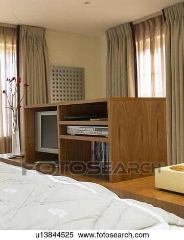 Television and DVD player on shelves in retractable storage unit in modern bedroom View Large Photo Image Stock Photography - Television and DVD player on shelves in retractable storage unit in modern bedroom. Fotosearch