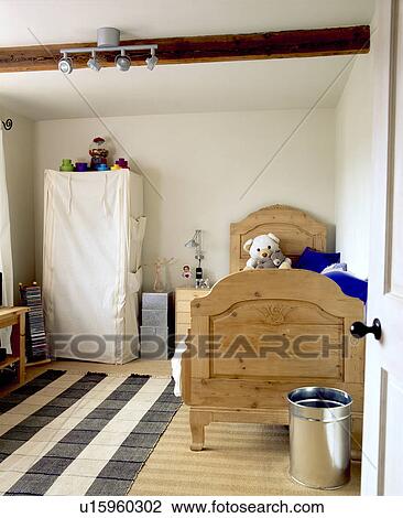 Tent wardrobe and wooden bed in child's white bedroom with black+cream striped rug on wooden floor View Large Photo Image Stock Image - Tent wardrobe and wooden bed in child's white bedroom with black+cream striped rug on wooden floor. Fotosearch