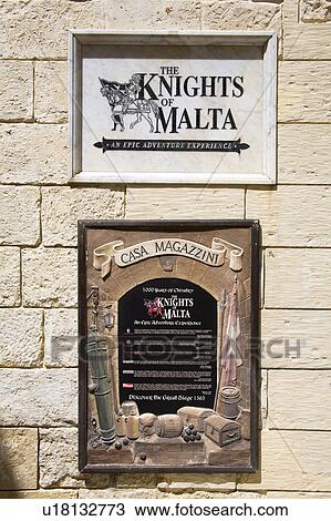 Stock Image - The Knights of Malta Experience sign, Casa Magazzini, Magazine Street, medieval city of Mdina, Malta. Fotosearch