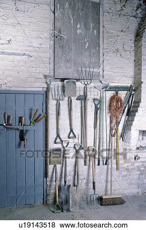 Stock Photo - Tools stored on walls inside large garden shed with blue door . Fotosearch