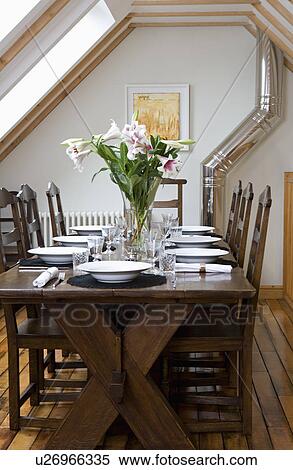 Stock Photography - Traditional oak table and chairs in modern cottage dining room extension. Fotosearch
