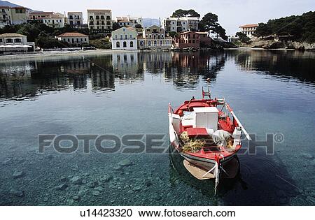 Stock Image - Traditional red fishing boat in the harbour at Assos on the island of Kefalonia in Greece&#10;. Fotosearch