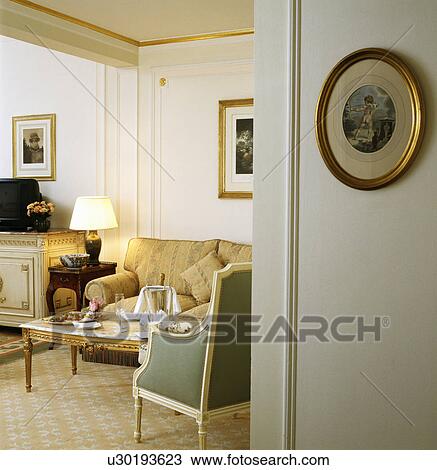 Traditional townhouse living room with lighted lamp on small table beside cream sofa View Large Photo Image Stock Image - Traditional townhouse living room with lighted lamp on small table beside cream sofa. Fotosearch