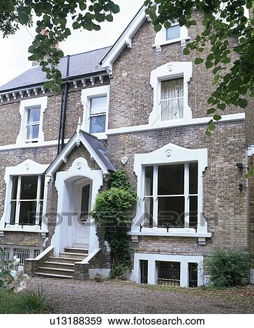 Stock Photo - Traditional Victorian detached house with steps up to front door with gabled porch. Fotosearch