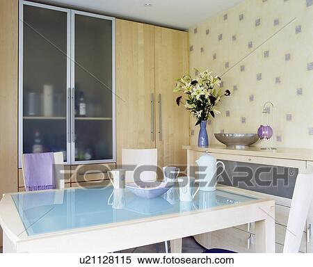 Turquoise-glass topped table in small modern dining room with glazed doors on fitted storage cupboard View Large Photo Image Stock Photography - Turquoise-glass topped table in small modern dining room with glazed doors on fitted storage cupboard. Fotosearch