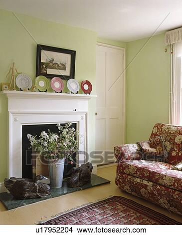 Vase of flowers in white fireplace in pastel green living room with red floral sofa View Large Photo Image Picture - Vase of flowers in white fireplace in pastel green living room with red floral sofa. Fotosearch