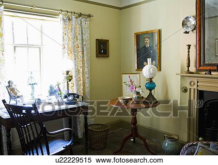 Victorian lamp on circular antique table in country study with old black telephone on desk View Large Photo Image Stock Photography - Victorian lamp on circular antique table in country study with old black telephone on desk. Fotosearch