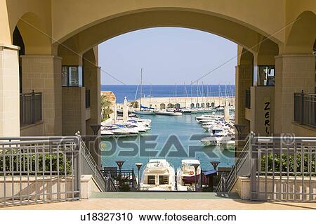 Stock Image - View through arch to Portomaso Marina at Saint Julian’s on the island of Malta. Fotosearch