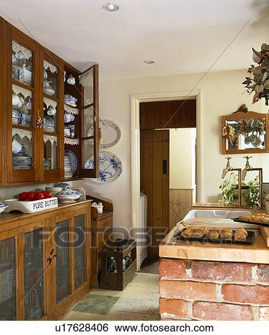Stock Photograph - Wall cupboard with glazed doors in small country kitchen. Fotosearch