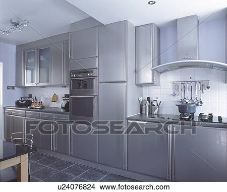 Wall mounted oven in modern metallic grey kitchen with slate floor tiles View Large Photo Image Picture - Wall mounted oven in modern metallic grey kitchen with slate floor tiles. Fotosearch