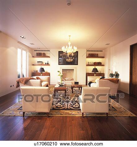 Stock Image - White armchairs in modern white living room with wooden flooring. Fotosearch